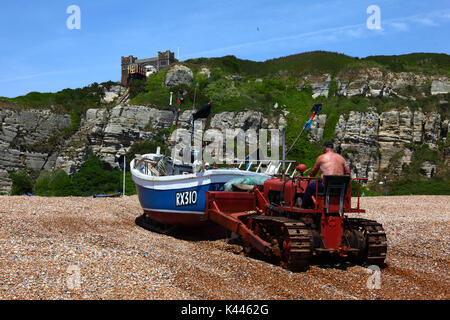 À l'aide de pêcheurs à bulldozer pousser jusqu'en bateau de pêche plage de galets, Hastings, East Sussex, Angleterre Banque D'Images