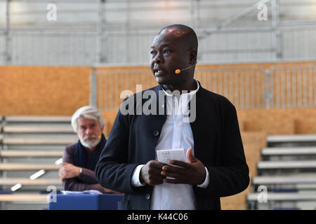 Berlin, Allemagne. 16Th Jun 2017. L'architecte Francis Kéré explique les plans d'un atellitentheater «' du Volksbuehne dans un hangar de l'ancien aéroport de Tempelhof pendant un communiqué de parler à Berlin, Allemagne, 4 septembre 2017. Directeur artistique Chris Dercon peut être vu à l'arrière. Photo : Paul Zinken/dpa/Alamy Live News Banque D'Images