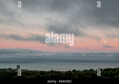 Eastbourne, East Sussex, Royaume-Uni. 4 septembre 2017. Lune se lève au coucher du soleil créant des couleurs pastel dans le ciel. Une soirée de bonne heure mais très chaude sur la côte sud. Banque D'Images