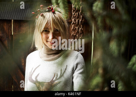 Femme blonde, coiffe, Garland avec églantier, les rameaux des arbres à feuillage persistant pour la décoration, portrait, Banque D'Images