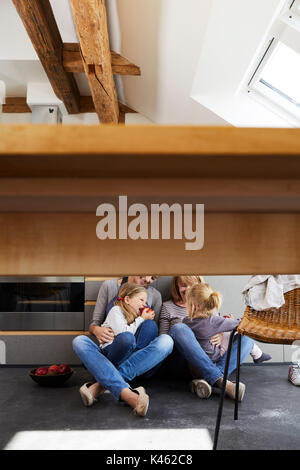 Grand-mère, la mère et les filles assis sur plancher de la cuisine, détail, table, chaise, Banque D'Images