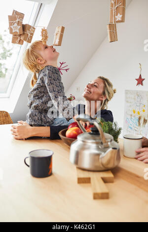 Mère et fille avec calendrier de l'avent, assis à une table de cuisine, Banque D'Images