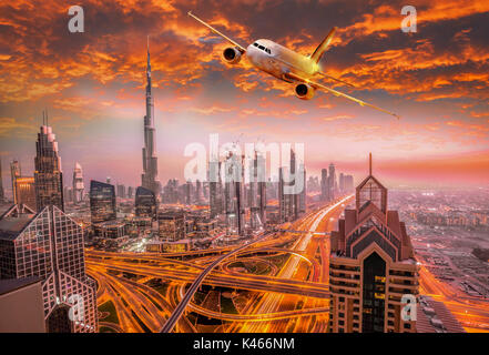 C'est avion volant au-dessus de Dubaï contre soleil colorés en Émirats arabes unis Banque D'Images