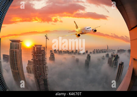 Avion est au-dessus de Dubaï contre soleil colorés en Émirats arabes unis Banque D'Images