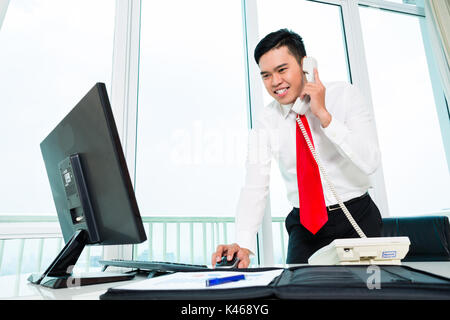 Asian businessman on phone in office Banque D'Images