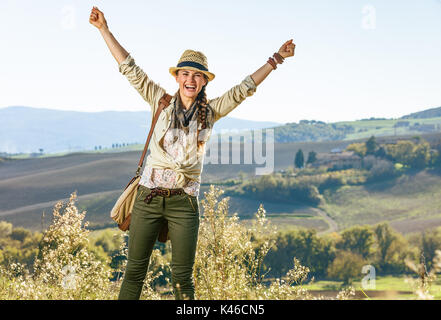 Découvrir une vue magique de la Toscane. smiling woman in hat randonneur actif avec sac sur la Toscane randonnée pédestre réjouissance Banque D'Images