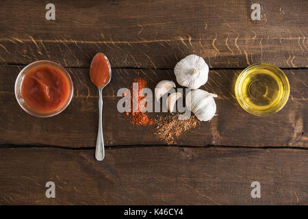 Vue de dessus de la sauce tomate avec de l'huile d'olive et l'ail avec table en bois sur les espèces Banque D'Images