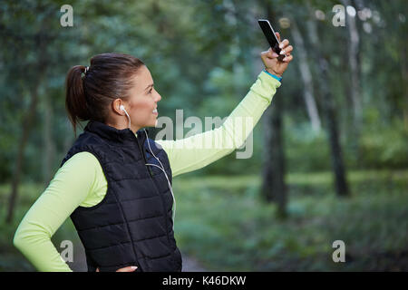 De côté de la sportive de prendre elle-même une photo. Banque D'Images