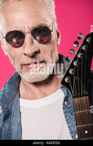Close-up portrait of handsome man élégant holding lunettes guitare électrique Banque D'Images
