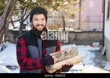 L'homme masculin transporter le bois pour le chauffage en hiver Banque D'Images