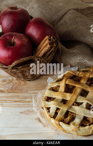 Tarte aux pommes maison et des ingrédients biologiques frais dans le panier sur la table rustique en bois Banque D'Images