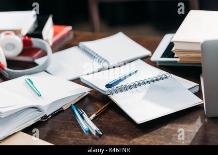 Vue rapprochée d'ouvrir les ordinateurs portables en blanc avec des stylos et des livres sur la table en bois Banque D'Images