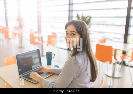 Portrait of young Beautiful woman working on laptop at cafe. Banque D'Images