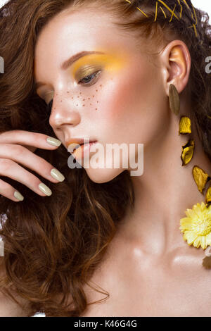 Portrait de la belle fille aux cheveux roux avec des boucles et le maquillage d'art. Beauté Visage. Photo prise dans le studio. Banque D'Images