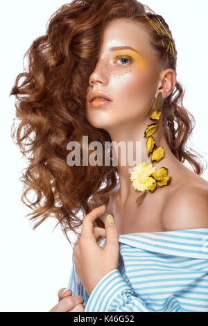 Portrait de la belle fille aux cheveux roux avec des boucles et le maquillage d'art. Beauté Visage. Photo prise dans le studio. Banque D'Images