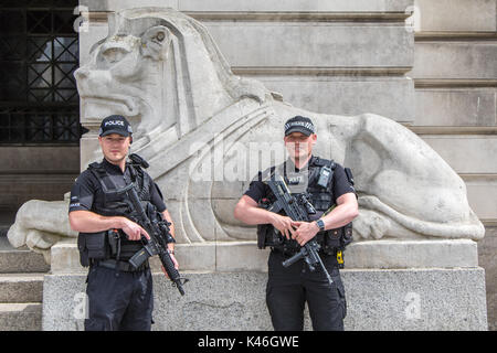 Deux agents de police armés mâle debout devant une statue de lion à l'extérieur du bâtiment du Conseil de Nottingham en place du Vieux Marché Banque D'Images