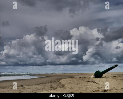 Bouée de navigation vert, échoués sur une plage vide sur un jour gris et froid dans l'ouest de la france. Banque D'Images