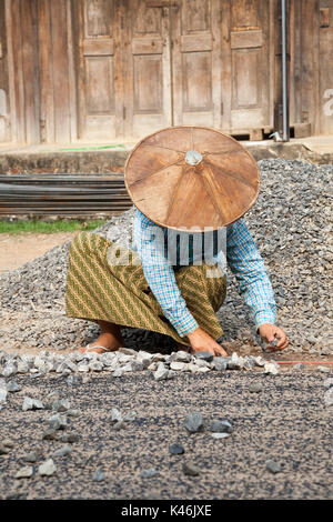 Female construction worker la réparation de route avec l'ensemble, Hsipaw, Myanmar Banque D'Images