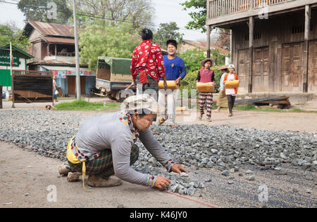 Female construction worker la réparation de route avec l'ensemble, Hsipaw, Myanmar Banque D'Images