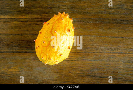 Melon jaune kiwano isolé sur vues de dessus de table en bois Banque D'Images