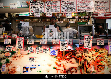 SEATTLE, WA, USA - Juin 2016 - vendeur non identifiés à l'horizon du marché aux poissons. Et les prix des marchandises à l'avant. Banque D'Images