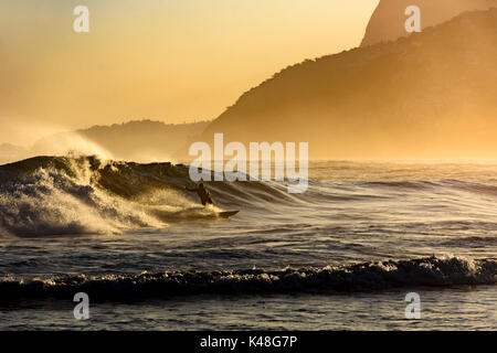 Surfer seul sur la plage d'Ipanema à Rio de Janeiro en fin d'après-midi Banque D'Images