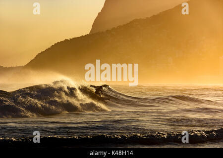 Surfer seul sur la plage d'Ipanema à Rio de Janeiro en fin d'après-midi Banque D'Images