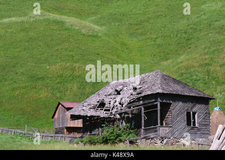 Ancienne maison en bois avec Green Grass Hills dans l'arrière-plan Banque D'Images