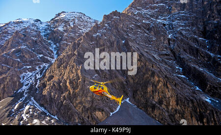 Hélicoptère Eurocopter AS350 Ecureuil contre un rocher, Alpes Suisses, Suisse Banque D'Images