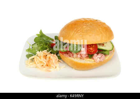 Salade de porc et du pain croûté dans un rouleau avec la garniture sur une assiette blanche contre isolés Banque D'Images