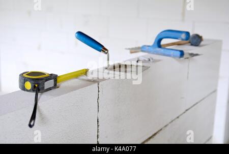 Outils de travail mis sur un mur de blocs de béton cellulaire autoclavé. Banque D'Images