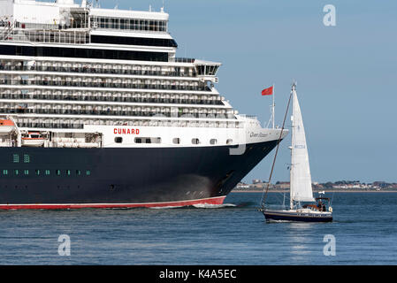 L'eau du sud de l'Angleterre Southampton UK. Août 2017. Bateau de croisière Queen Elizabeth en cours passant un yacht et ayant quitté le port de Southampton Banque D'Images