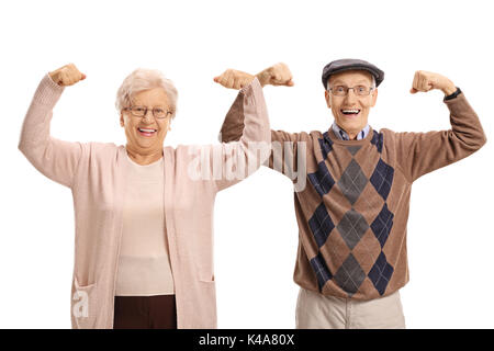 Les aînés joyeuse leur flexion des biceps et regardant la caméra isolé sur fond blanc Banque D'Images