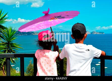 Deux enfants profitez de l'affichage d'un paysage magnifique clif haut de Baia, Italie. Banque D'Images