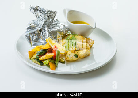 Du poisson cuit au four dans une feuille d'aluminium de persil pommes de terre et légumes beurrés Banque D'Images