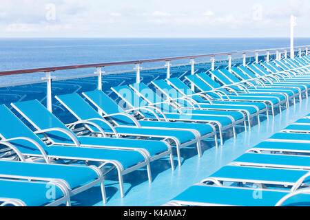 Chaises longues bleu sur le pont d'un arrière-plan avec l'océan Atlantique Banque D'Images