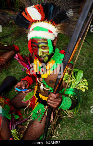 Mehiwaga warrior tapant dans son smartphone, la tribus des hauts plateaux se présentent à l'assemblée annuelle de sing sing goroka Banque D'Images