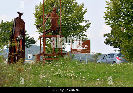 Geisa, Allemagne. Août 22, 2017. Scluptures de l'artiste allemand Ulrich Barnickel sur le site de l'ancienne frontière allemande-intérieure séparant l'état allemand est de Thuringe à partir de l'Ouest Etat allemand de Hesse à Geisa, Allemagne, 22 août 2017. Un panneau dans l'arrière-plan se lit "l'Allemagne et l'Europe ont été divisés ici jusqu'à 11 h le 22 décembre 1989. Le point Alpha memorial site contient une exposition consacrée à l'histoire de la division de l'Allemagne en deux Etats distincts pendant la guerre froide. Photo : Jens Kalaene Zentralbild-/dpa/ZB/dpa/Alamy Live News Banque D'Images