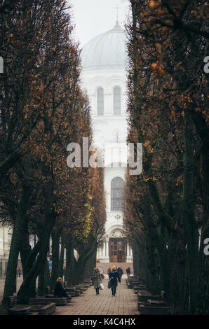 Kaunas, Lituanie - 7 novembre 2014 : les résidents locaux sur la rue de Laisves Aleja . Les Archanges Saint Michel church dans le brouillard sur le backgroun Banque D'Images