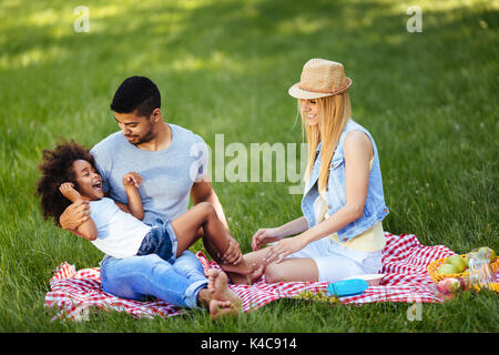 Photo de jolie couple avec leur fille having picnic Banque D'Images