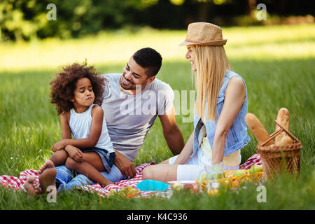 Offensé petite fille assise avec les parents sur l'aire de pique-nique Banque D'Images