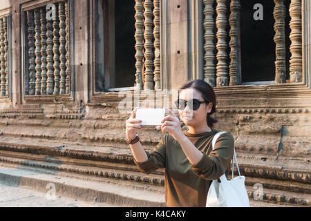 Female traveler prenant des photos avec son smartphone à Angkor Wat siem reap Cambodge Banque D'Images