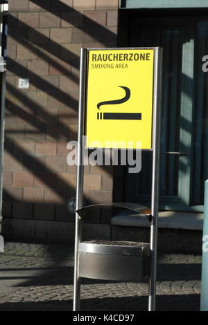 Zone fumeurs avec panneau jaune et cendrier sur un aéroport Banque D'Images