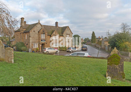 Le Kings Arms pub et le village high street farthingstone, vue de l'église cimetière ; northamptonshire, Angleterre Banque D'Images