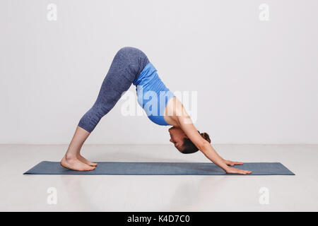 Femme d'Ashtanga vinyasa yoga asana Adhomukha Svanasana Banque D'Images