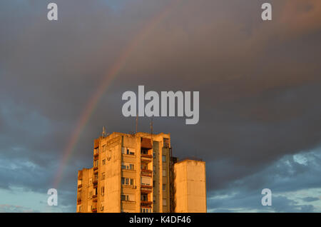 Sur un arc-en-ciel des pluies sombres nuages sur un bâtiment résidentiel, juste après une forte pluie Banque D'Images