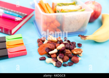 Déjeuner à l'école fort avec sandwich, légumes, eau, noix et fruits sur fond bleu turquoise. De saines habitudes alimentaires concept Banque D'Images