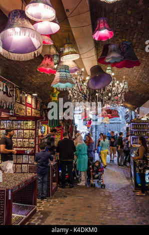 Les gens se rassemblent autour de stands dans le marché de chevaux dans la région de Camden Market à Camden Town, Londres. Des tons clairs pendent du plafond. Banque D'Images