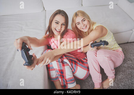 Portrait de dessus de happy female friends en pyjama à jouer aux jeux vidéo. Banque D'Images