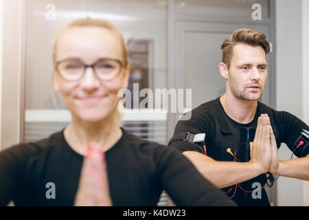 Close up portrait avant de sportif et son entraîneur en yoga pose Banque D'Images